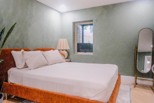 a bedroom with a large white bed and a window at Charming Garden Lvl Brownstone in Brooklyn
