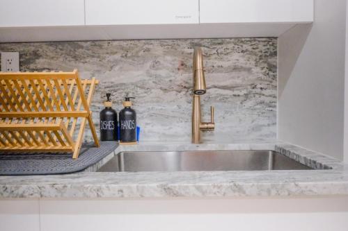 a kitchen sink with two bottles of soda at Charming Garden Lvl Brownstone in Brooklyn