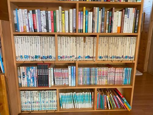a book shelf filled with lots of books at Yanggang house in jeju in Kosŏng-ni