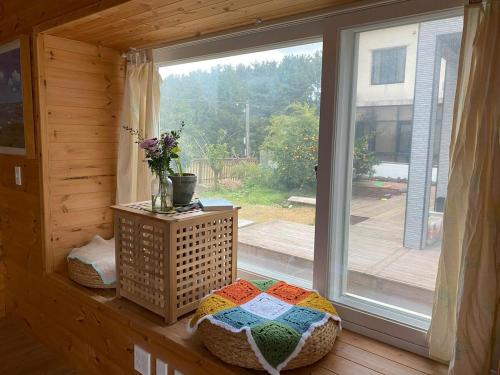 a window in a room with a bed in front of a window at Yanggang house in jeju in Kosŏng-ni
