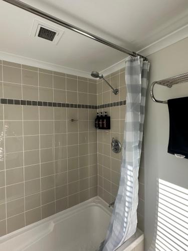 a bathroom with a shower with a bath tub at City Lights Retreats - 2 Bedroom, 1 Bathroom in Perth
