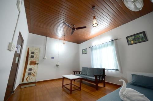 a living room with a couch and a table at jasmine land homestay in Udupi