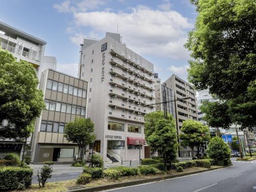a tall white building on the side of a street at KOKO HOTEL Yokohama Tsurumi in Yokohama