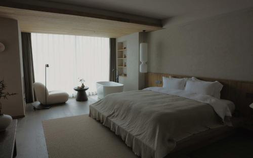 a bedroom with a large bed and a large window at Siguniang Mountain Star Moon Cliff Hotel in Mount Siguniang