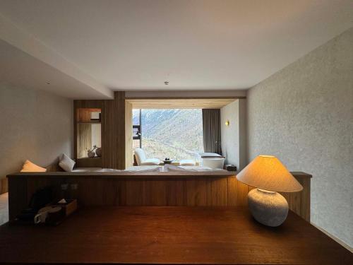 a bedroom with a bed and a lamp on a table at Siguniang Mountain Star Moon Cliff Hotel in Mount Siguniang