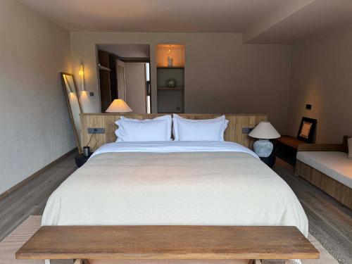 a bedroom with a large white bed and a couch at Siguniang Mountain Star Moon Cliff Hotel in Mount Siguniang