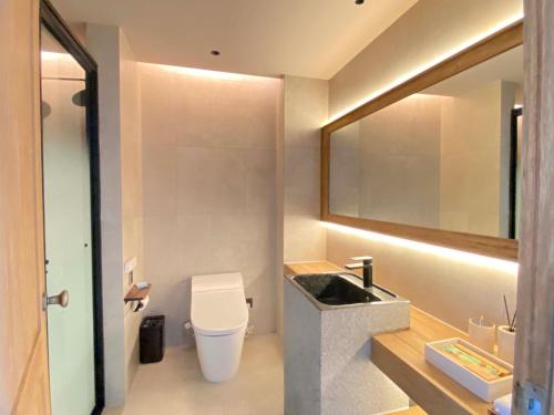 a bathroom with a sink and a toilet and a mirror at Siguniang Mountain Star Moon Cliff Hotel in Mount Siguniang