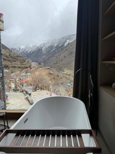 a view of a mountain from a window with a keyboard at Siguniang Mountain Star Moon Cliff Hotel in Mount Siguniang