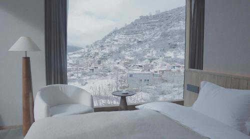 a bedroom with a bed and a view of a mountain at Siguniang Mountain Star Moon Cliff Hotel in Mount Siguniang