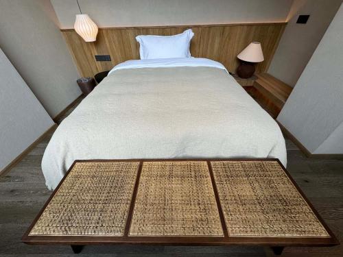 a bedroom with a large bed with a wooden table at Siguniang Mountain Star Moon Cliff Hotel in Mount Siguniang
