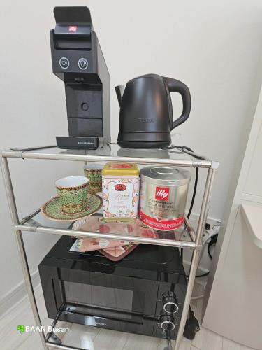 a shelf with a coffee pot and food on it at Baan Busan - 3mins to Haeundae Beach in Busan