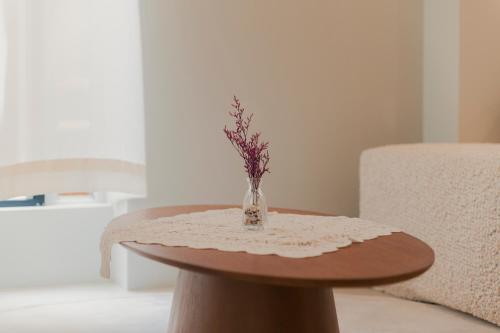 a round table with a vase of flowers on it at Yeobaek Hotel in Incheon