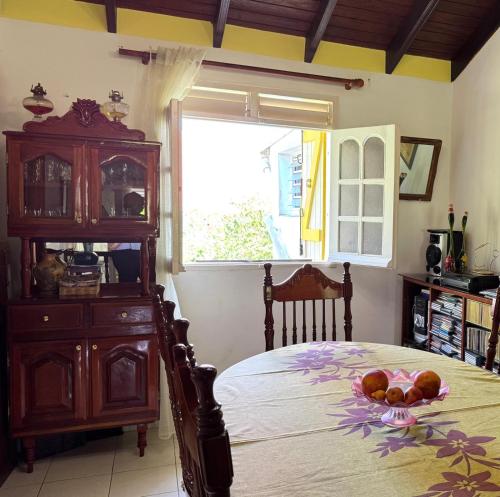 ein Schlafzimmer mit einem Bett mit einer Kommode und einem Fenster in der Unterkunft Paradis Créole à Bellevue Sainte-Rose in Sainte-Rose