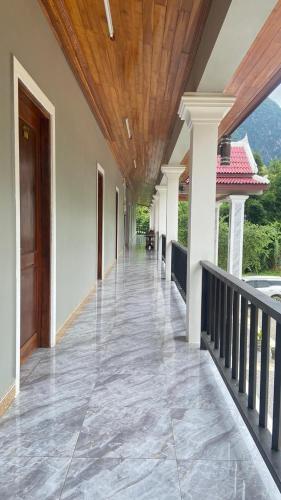 an empty hallway of a house with a wooden ceiling at Houngvilai Guesthouse in Ban Sôphoun