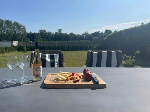 a plate of food on a table with a bottle of wine at Holiday Home By The Beach Near Stevns in Strøby