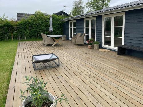 a wooden deck with chairs and a table on a house at Holiday Home By The Beach Near Stevns in Strøby