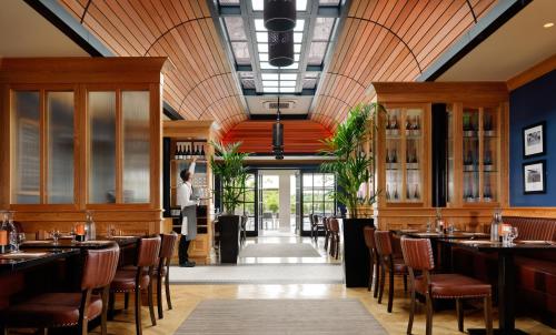 een restaurant met houten plafonds en tafels en stoelen bij Ballygarry Estate Hotel & Spa in Tralee