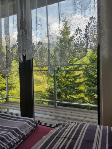 a bedroom with a window with a view of a tree at UBYTOVANIE POD GERLACHOM in Vysoké Tatry