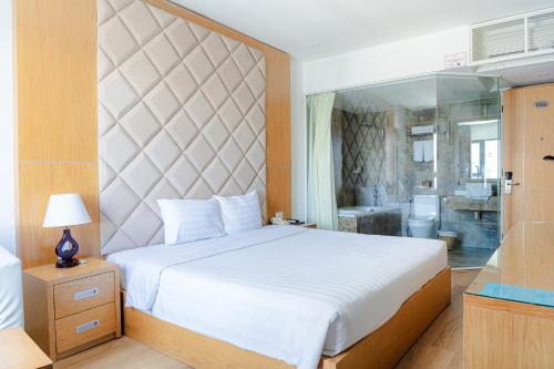 a bedroom with a large white bed and a bathroom at Terra boutique hotel in Da Nang