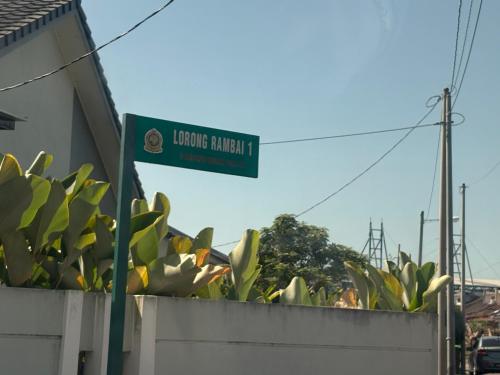 a green street sign on top of a wall at HoMestaY Kulim Seri Rambai in Kulim
