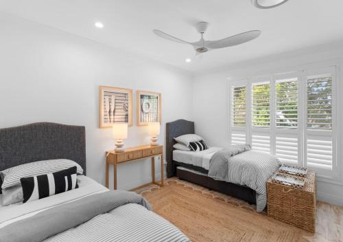 a bedroom with two beds and a ceiling fan at Riverview Apartment 2.4 in Iluka