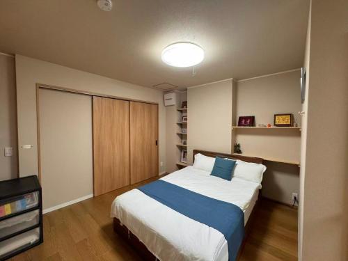 a bedroom with a large bed and a television at Cozy House Namba in Osaka