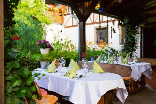 a group of tables with white table cloths on them at Kräuterhotel Garni Zur Klostergrotte in Nohra