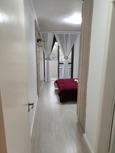 a bedroom with a bed and a large window at Apartamento com vista para lagoa in Caxias do Sul