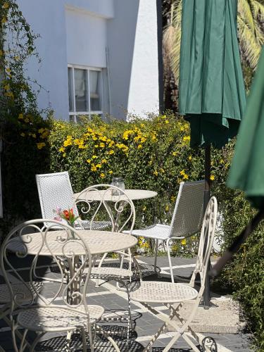 a group of chairs and tables and an umbrella at Mekenificent Stays in Windhoek