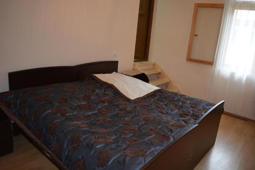 a bed with a blue comforter in a bedroom at Mziuri Guest House in Mestia