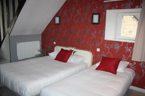 two beds in a room with red walls at Hôtel République in Dijon