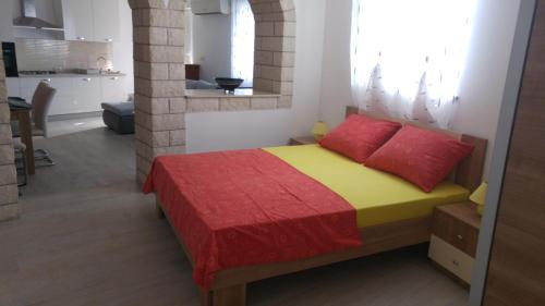 um quarto com uma cama com duas almofadas vermelhas em Apartments and room Suza em Senj