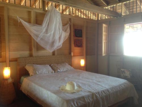 a bedroom with a bed with a hat on it at Finca El Regalo in Capurganá