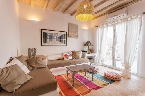 a living room with a couch and a table at Mykonos Dunes Villas in Mikonos