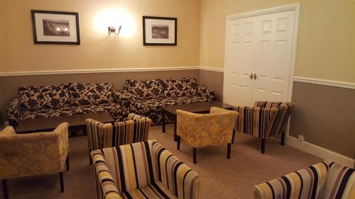 a waiting room with a couch and chairs at Nant Ddu Lodge Hotel & Spa in Merthyr Tydfil