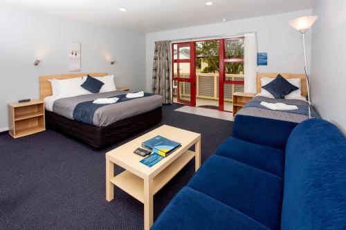una habitación de hotel con un sofá y una cama en Carters Beach Top 10 Holiday Park, en Carters Beach