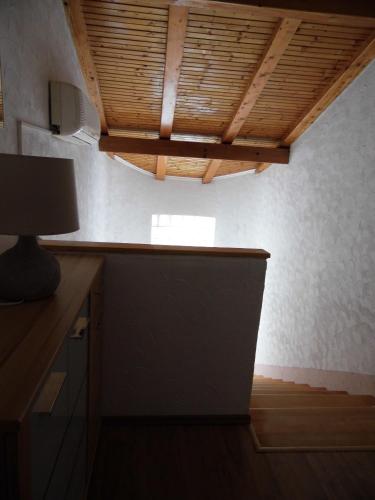 a kitchen with a wooden ceiling with a lamp at B&B Eva in Ičići