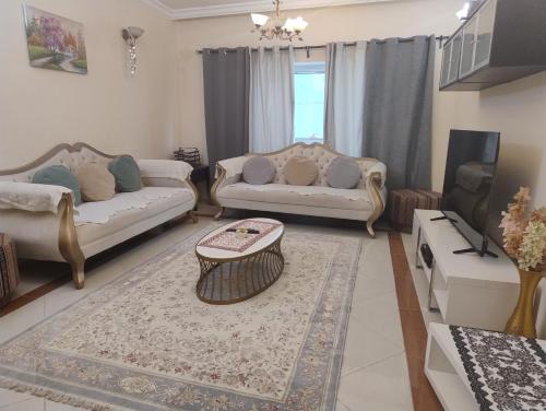 a living room with two couches and a coffee table at Cityscape Retreat Apartment in Sharjah