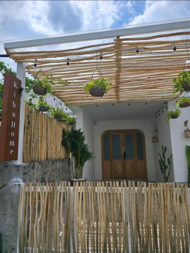 a wooden fence in front of a house with plants at Kihu Home Phan Thiet in Bình Sum