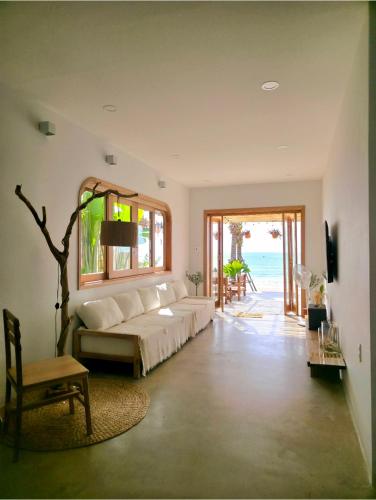 a living room with a white couch and a window at Kihu Home Phan Thiet in Bình Sum