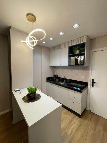 a kitchen with white cabinets and a white counter top at Studio Flat Cuiabá in Cuiabá