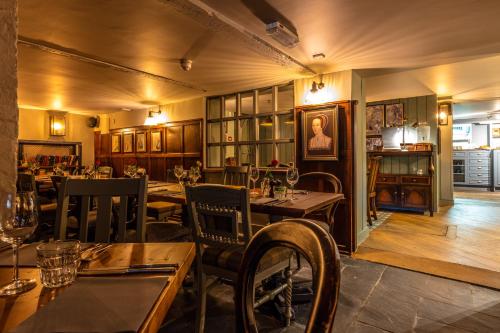 a restaurant with tables and chairs in a room at Greyhound Hotel in Sutton