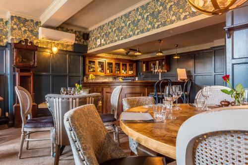 a restaurant with a wooden table and chairs at Greyhound Hotel in Sutton
