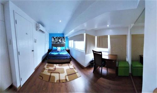 a bedroom with a bed and a desk and a table at 2 BR loft-type condo Fort Victoria in Manila