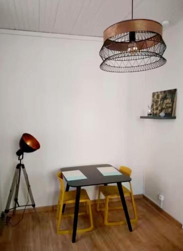 a table and chairs in a room with a light at Escale meublée in Belfort