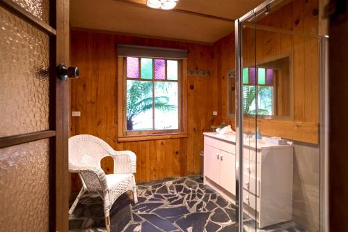 a bathroom with a shower and a sink and a mirror at Saintys Creek Cottage in South Bruny