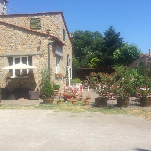 a stone house with potted plants in front of it at La Palazzina in Chiusdino