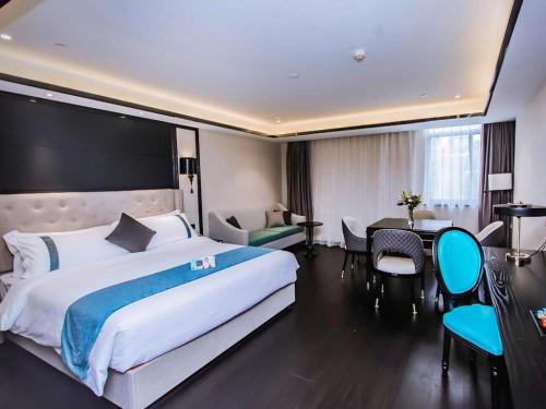 a hotel room with a large bed and a desk at Xana Hotelle Wuxi Railway Station Zhongshan Road in Wuxi