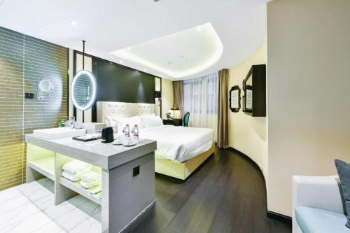 a hotel room with a bed and a bathroom at Xana Hotelle Wuxi Railway Station Zhongshan Road in Wuxi