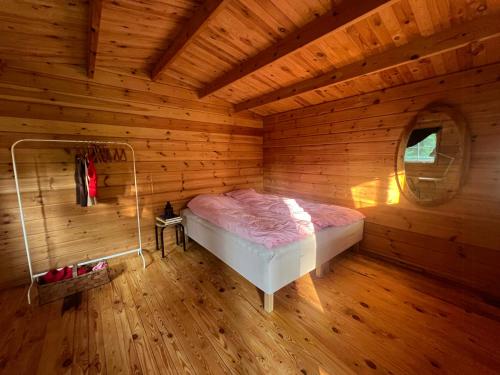a bedroom with a bed in a wooden room at Wonderfull House By Liseleje Strand in Melby